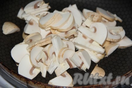 Шампиньоны промыть водой, нарезать на пластинки. В сковороду, разогретую с растительным маслом, выложить нарезанные грибы.
