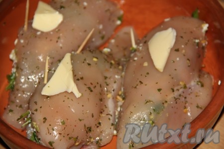 Положить кусочки масла поверх мяса. Поставить форму с куриным филе, фаршированным творогом и зеленью, в разогретую духовку и запекать минут 30 при температуре 200 градусов.
