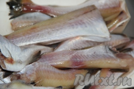 Минтая разморозить при комнатной температуре, промыть под водой, удалить голову, внутренности и чёрную плёночку внутри брюшка, отрезать плавники и хвост.
