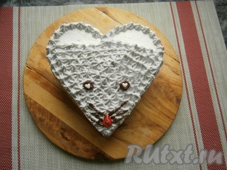 Глазки и усики нарисовать предварительно растопленным чёрным шоколадом, который поместить в кондитерский одноразовый мешок (или в уголок целлофанового пакета, обрезав кончик). Зрачки - из капель белого шоколада (или белой кондитерской посыпки), носик - окрашенная красным красителем капля из белого шоколада.
