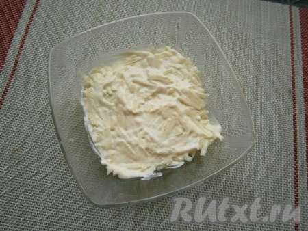 Натереть яблоко на средней (или крупной) тёрке, сбрызнуть лимонным соком, перемешать и выложить в салатник. Смазать слой яблок майонезом, чуть посолить.
