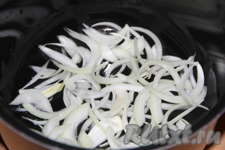 Лук очистить и нарезать тонкими полукольцами. Помидоры вымыть, нарезать на полукружки. На дно чаши мультиварки выложить половину нарезанного лука.
