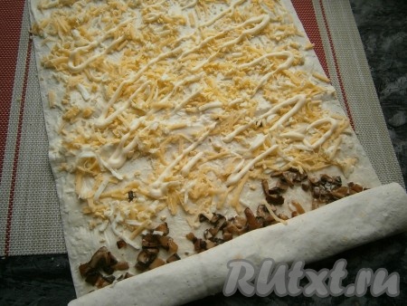 Грибы немного сверху смазать майонезом и свернуть эту часть лаваша в рулет. На другую часть лаваша выложить смесь сыра и яиц, также сверху смазать немного майонезом.
