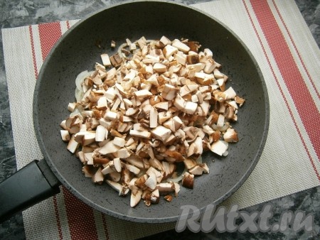 Нарезанные шампиньоны добавить к обжаренному луку, посолить и поперчить.
