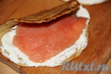 На часть овсяноблина, смазанную сыром, выложить кусочек красной рыбы.
