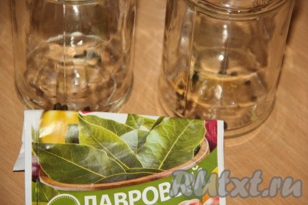 На дно каждой чистой банки выложить лавровый лист, добавить 3 горошины чёрного перца.