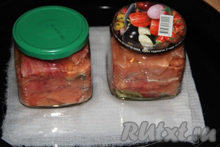 Влить на противень воду (вода должна покрывать противень, примерно, на 1-1,5 см). Поставить противень с банками в холодную духовку! Включить духовку на температуру 150 градусов и готовить 1 час. Затем увеличить температуру в духовке до 180-200 градусов и готовить консервы из горбуши ещё 2,5 часа.
