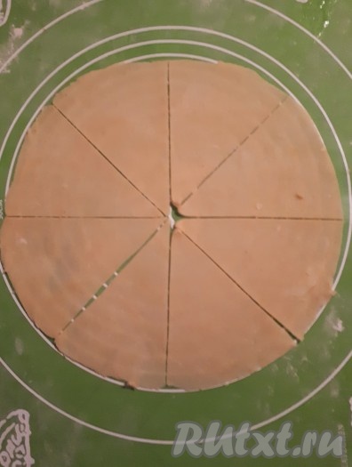 Охлаждённое тесто разделить на 4 части. На столе, припылённом мукой, поочередно каждую часть теста раскатать в круг. Разделить круг на 8 частей.