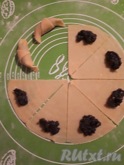 На каждую часть круга выложить по чайной ложечке маковой начинки и сформировать рогалики.