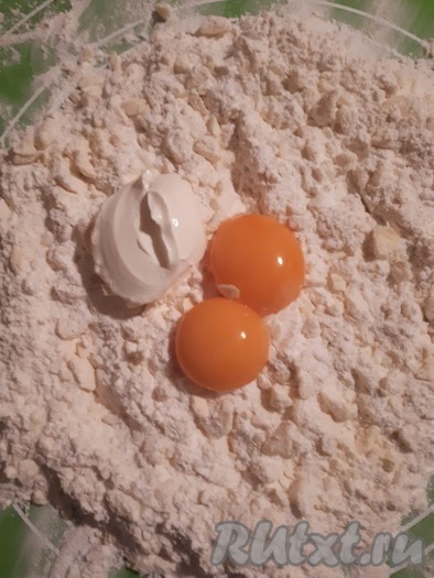 Добавить желтки, сметану и быстро замесить тесто. Консистенцию теста регулируем сметаной, то есть, если тесто с трудом собирается в комок, нужно добавить ещё немного сметаны.