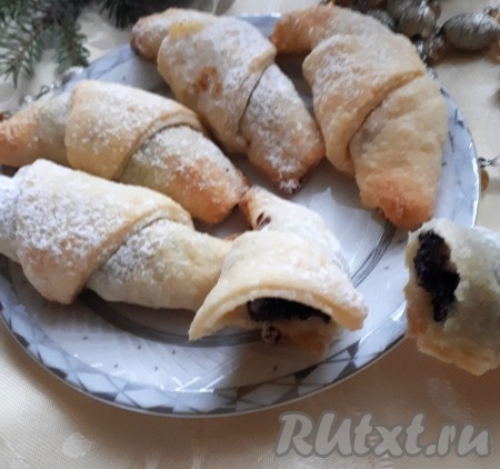 Испечённые рогалики немного остудить и переложить на блюдо. Посыпать сахарной пудрой.