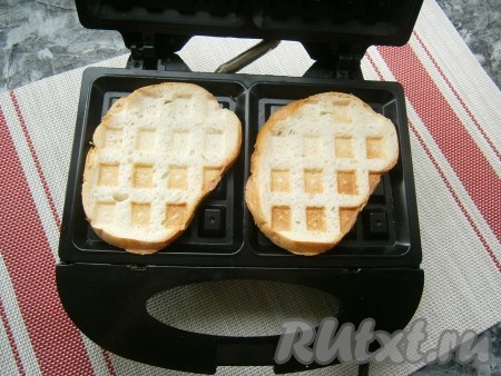 Батон нарезать на ломти, каждый ломоть подсушить и немного поджарить на сухой сковороде с двух сторон (или, как сделала я, - в электровафельнице в течение 1-2 минут, можно подсушить и в тостере).
