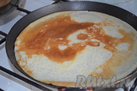 Очень хорошо разогреваем сковороду, слегка смазываем её маслом перед выпечкой первого блинчика (в дальнейшем сковороду можно не смазывать, так как масло входит в состав теста, но многое зависит от качества сковороды), наливаем часть теста, равномерно распределяя его по поверхности сковородки и жарим вначале с одной стороны до румяности на среднем огне, после этого аккуратно переворачиваем и жарим с другой стороны до зарумянивания. Перекладываем готовый блин на тарелку, а из оставшегося теста жарим один за другим все блины.