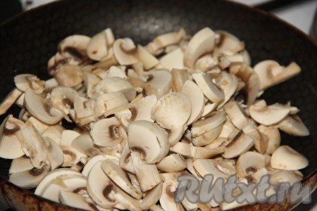 Шампиньоны промыть под водой, нарезать на пластинки и выложить в разогретую с растительным маслом сковороду.
