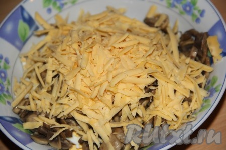 Сюда же выложить и сыр, натёртый на крупной тёрке, слегка посолить салат.
