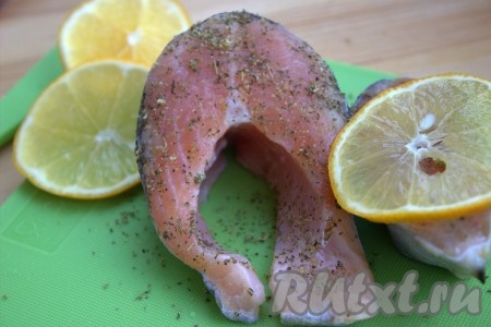 Разрезать форель на порционные кусочки. Я разрезала на стейки шириной, примерно, 3-4 сантиметра. Рыбу посолить, приправить специями по вкусу (я использовала универсальную приправу для рыбы). Поверх каждого стейка форели выложить по одной дольке лимона.
