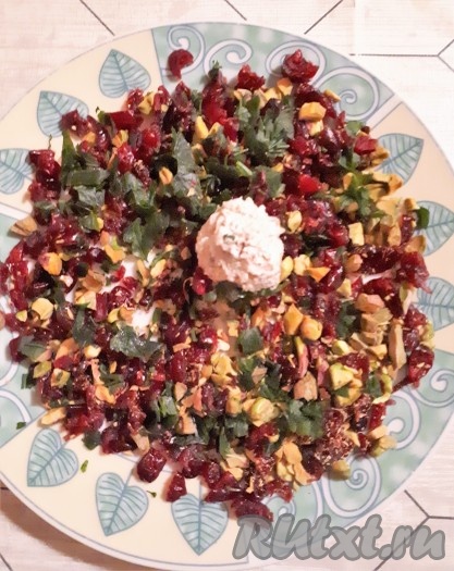 Из сырной массы сформировать шарики величиной с грецкий орех и обвалять их в смеси клюквы, орехов и петрушки.