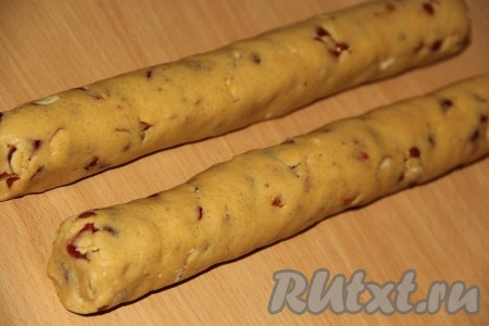 Вмесить клюкву в тесто. Разделить тесто на две части, сформировать колбаски диаметром 3-4 сантиметра.