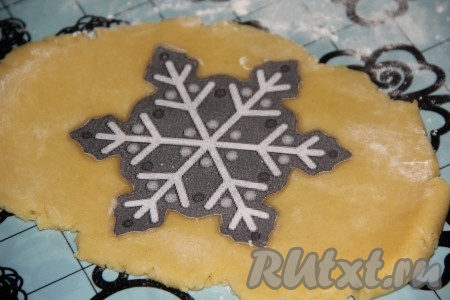 По прошествии времени тесто разделить на несколько частей. С частью теста работаем, а остальное тесто должно лежать в холодильнике. Раскатать часть теста скалкой на столе, присыпанном мукой, в пласт толщиной 5-7 миллиметров. Вырезать печенье любой формы с помощью формочек или трафаретов (я сделала трафарет в виде снежинки и вырезала печенье ножом).