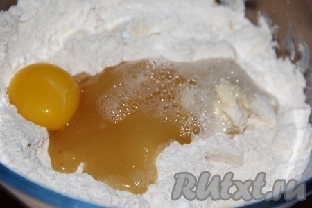 Погашенную соду влить в миску с крошкой, мёдом и желтком.