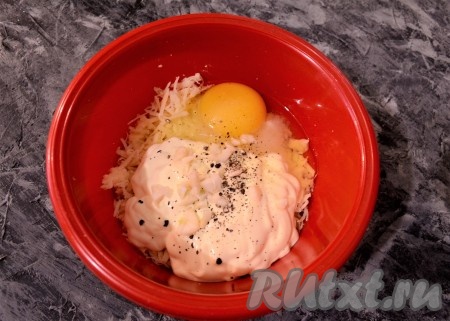 Половину сыра отложить в другую миску. В оставшийся сыр добавить 1 яйцо, майонез, измельчённый чеснок, соль и чёрный молотый перец по вкусу.
