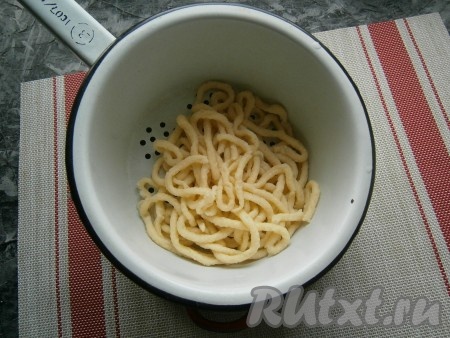 Варить лапшу в кипящей воде 1-1,5 минуты, после чего откинуть её на дуршлаг. Аналогично отварить в кипящей воде лапшу из жидкого теста, оставшегося в кондитерском мешке.
