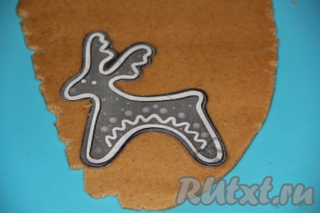 Готовое тесто разделить на несколько частей, пока с одной частью работаем, оставшееся тесто пусть лежит в холодильнике. Одну часть теста скалкой раскатать в пласт толщиной 5-7 мм и вырезать пряники, используя трафарет (или вырубки для пряников).
