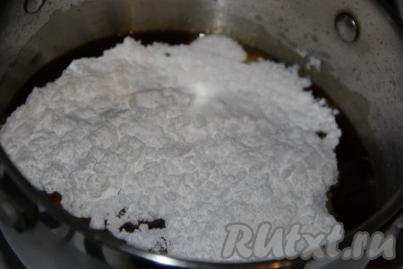 Жжёный сахар должен стать красивого коричнево-красного цвета. Когда жжёнка приобретёт нужный цвет, влить в неё небольшими порциями, перемешивая, 100 мл крутого кипятка и на небольшом огне, помешивая, довести до кипения. Затем всыпать 150 грамм сахарной пудры и лимонную кислоту на кончике ножа.
