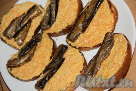 Затем на каждый бутерброд выложить 2-3 шпротинки.