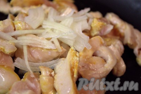 В глубокую сковороду влить растительное масло, добавить нарезанное куриное филе и обжарить на сильном огне до изменения цвета мяса (в течение 2-3 минут), немного посолить. Лук очистить, нарезать тонкими полукольцами и добавить в сковороду к куриному мясу, перемешать, уменьшить огонь до среднего и обжарить, не забывая иногда помешивать, минуты 3.
