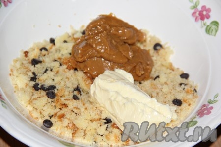 Слегка перемешать бисквитные крошки с шоколадом. Добавить варёную сгущёнку и мягкое масло.
