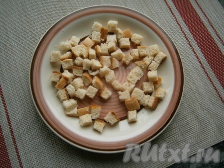 Отправить тарелку в микроволновку, выставить мощность 750 Ватт. Включить СВЧ на 30 секунд, затем сухарики нужно обязательно перемешать и снова аккуратно выложить в один слой. Ещё раз поставить тарелку в микроволновку на 30 секунд и затем снова сухарики из белого хлеба перемешать. За это время они уже подсохнут и уменьшатся в размере.
