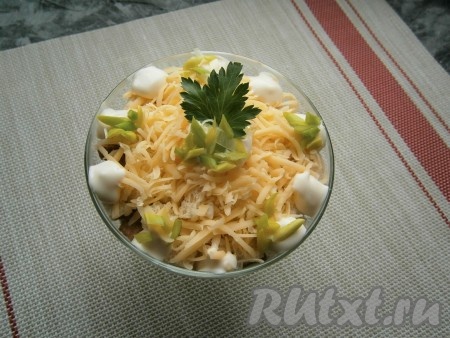 И верхним слоем выложить натёртый на средней терке сыр. По краю салата можно выдавить немного майонеза. Украсить салат зеленью лука и петрушки.

