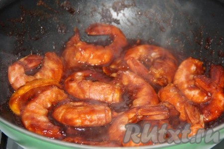 Томить лангустинов в соевом соусе и кетчупе на слабом огне в течение 4 минут.