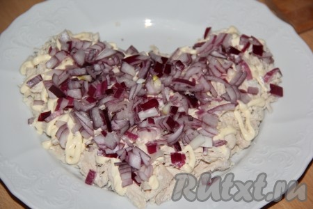 Лук очистить, нарезать на тонкие полоски. Я готовила салат с красным луком, он не горчит, если же вы готовите с обычным репчатым луком, тогда нарезанный лук выложите в дуршлаг, обдайте кипятком, дайте воде стечь и оставьте на пару минут, чтобы лук остыл. Поверх куриного филе равномерно выложить лук.