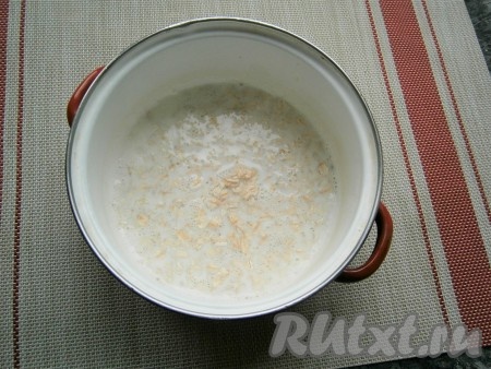 Как только закипит молоко, всыпать в кастрюлю овсяные хлопья, перемешать. Проварить овсянку на медленном огне под прикрытой крышкой в течение 5 минут, после чего плотно закрыть крышкой, снять с огня, накрыть тёплым полотенцем. Оставить кашу на 10 минут.
