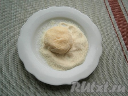 Далее влажными руками из этой массы скатать шарики любого удобного для вас размера, сформировать лепёшки и обвалять их в манной крупе.
