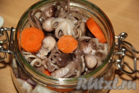 Далее добавить кружочки варёной моркови. Таким образом, чередуя, заполнить всю банку слоями из лука, осьминогов и моркови.
