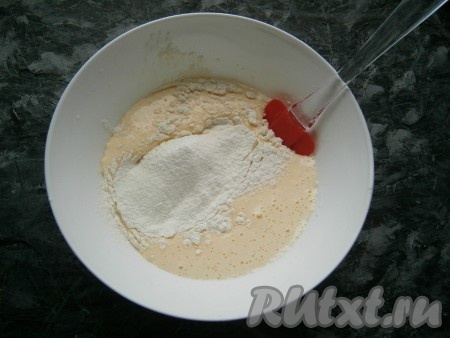 Частями просеять в яичную массу муку с разрыхлителем, каждый раз аккуратно и хорошо вмешивая муку с помощью лопатки.
