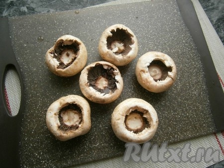 Лук и чеснок очистить. Крупные шампиньоны вымыть, обсушить, удалить ножки так, чтобы в грибах получилось отверстие. Внутри шампиньоны немного посолить.
