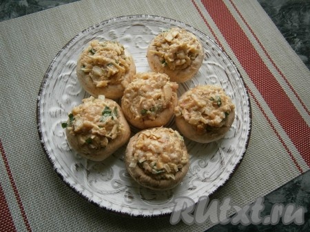 Полученной массой щедро (с горкой) нафаршировать шампиньоны, разместить их на тарелке, пригодной для готовки в СВЧ.