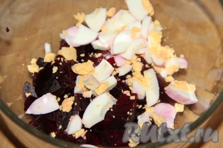 Свеклу нарезать на средние кусочки и выложить в глубокую миску, добавить яйца, нарезанные на дольки.
