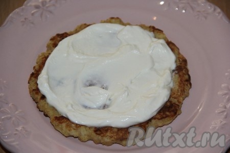 Выложить первый овсяноблин на плоскую тарелку, смазать кремом.
