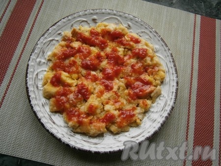 Аккуратно перемешать, чтобы каждый кусочек хлеба соприкоснулся с яйцом. Хлебную массу выложить на немного смазанную растительным маслом тарелку, пригодную для готовки в СВЧ, в виде круглой лепёшки. Смазать хлеб кетчупом (или томатным соусом).
