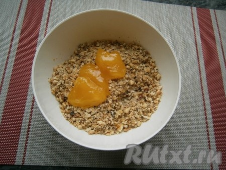 Растопить 20 грамм сливочного масла (я растопила в микроволновке), дать немного остыть. Крошку из орехов и печенья пересыпать в миску, влить растопленное масло, добавить 3 столовых ложки мёда, который должен быть тягучим (если мёд засахаренный - растопите его до нужного состояния на водяной бане или в микроволновке).
