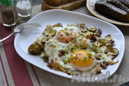 Теперь очень вкусную яичницу, приготовленную с солёными огурцами, поперчить и можно подавать к столу!
