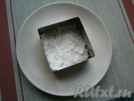 На плоскую тарелку выкладывать салат слоями с помощью формочки (или кулинарного кольца). Первым слоем выложить куриное филе, смазать его соусом из йогурта и майонеза.
