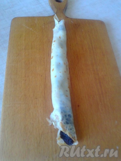 Сверните половинку блина с начинкой в трубочку.