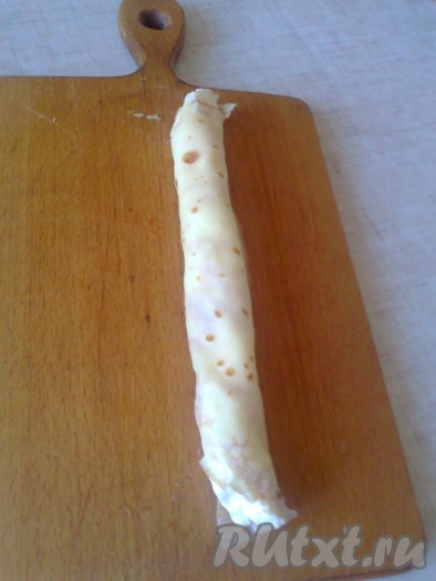 Сверните половинку блина с начинкой в трубочку.