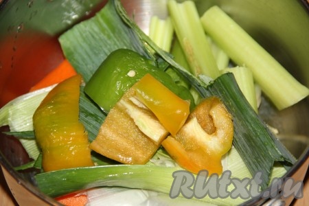 Листья лука-порея вымыть и добавить в кастрюлю. Вымыть, удалить семена с плодоножкой из 1 болгарского перца (я решила взять половину оранжевого перца и половину зелёного перца), крупно нарезать и добавить в кастрюлю с овощами.
